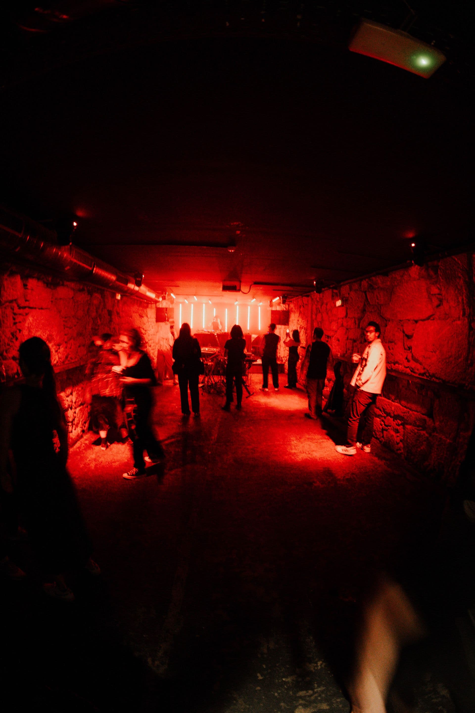 Raw / Hypnotic / Deep techno — underground stone-walled basement rave